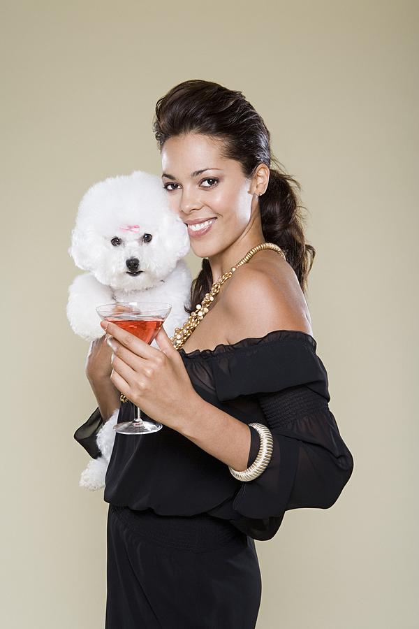 Woman holding dog and cocktail glass Photograph by Image Source