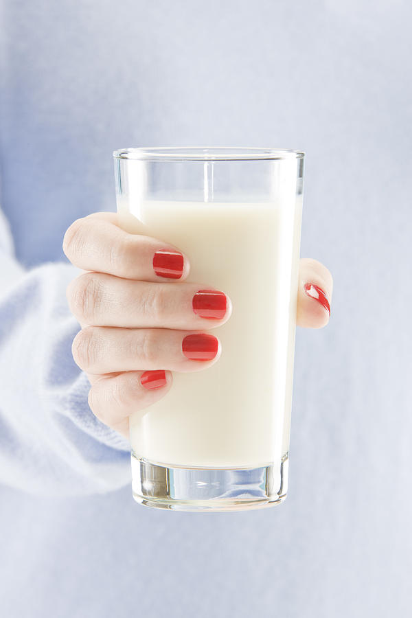 Woman holding glass of milk Photograph by Tooga
