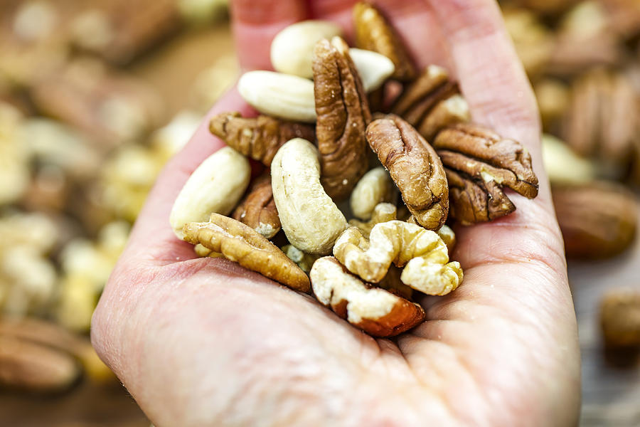 Woman holding handful of fresh nuts. Mixed whole nuts. Nut Sources of Vitamin B9 Folate Photograph by Mikroman6