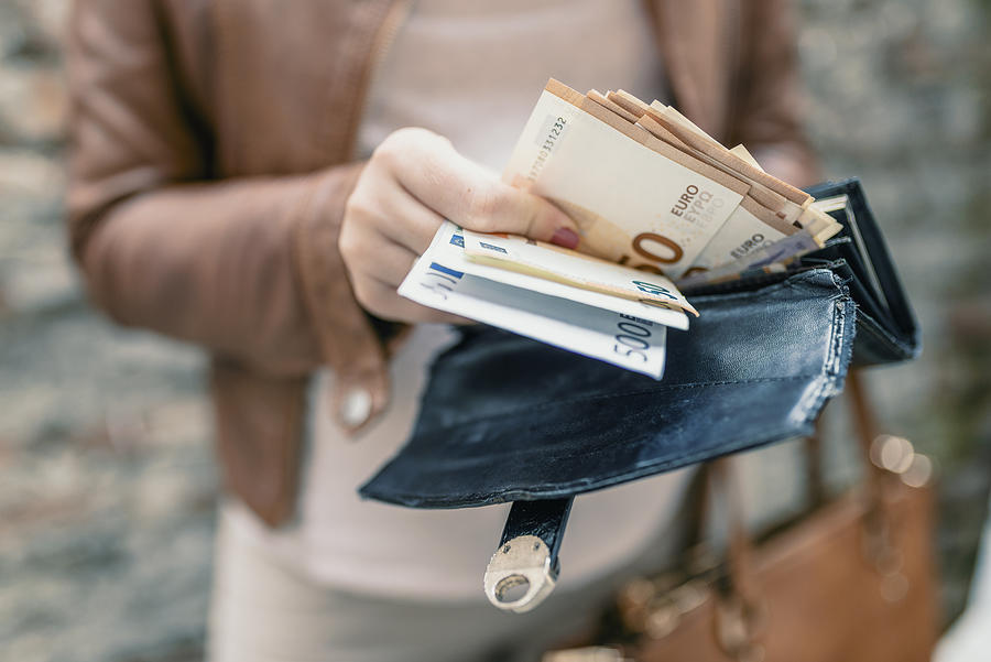 Woman holding in hands wallet with euro money. City girl is taking out money from wallet Photograph by Dragana991