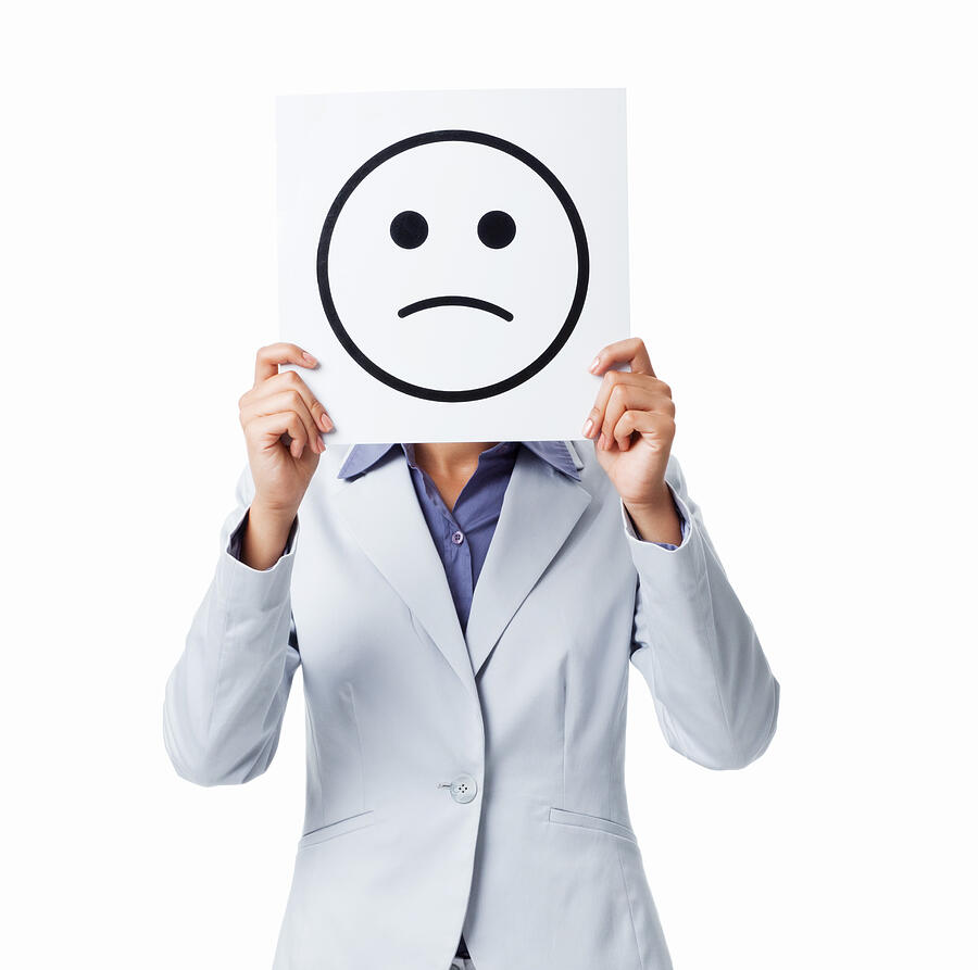 Woman Holding Sad Smiley Sign - Isolated Photograph by Neustockimages