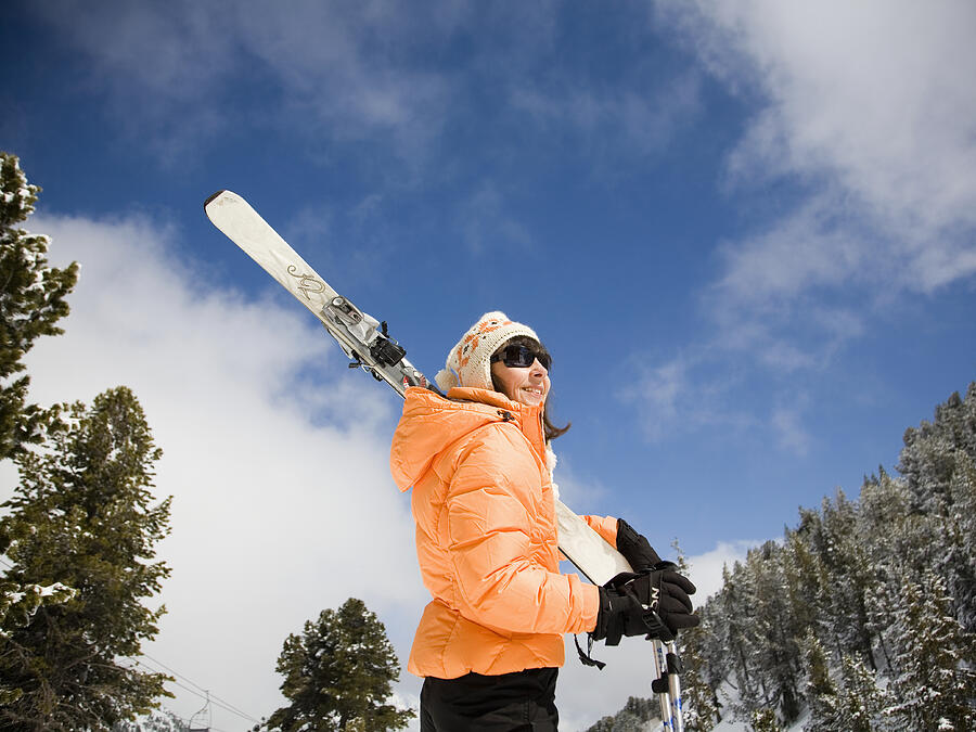 Woman holding skis in snowy landscape Photograph by Ashley Jouhar