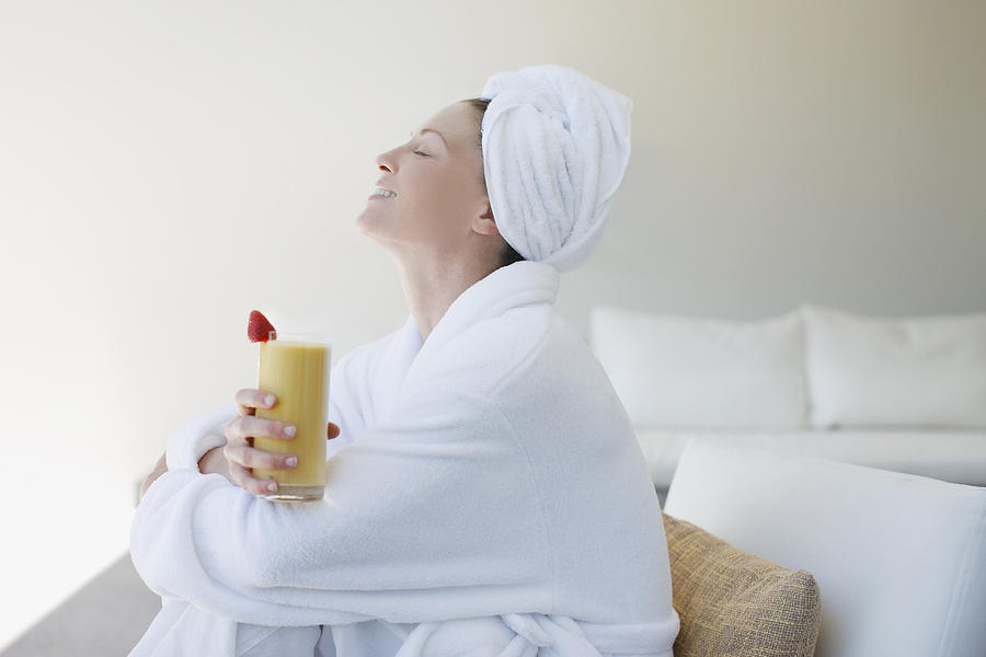 Woman in bathrobe drinking smoothie Photograph by Tom Merton