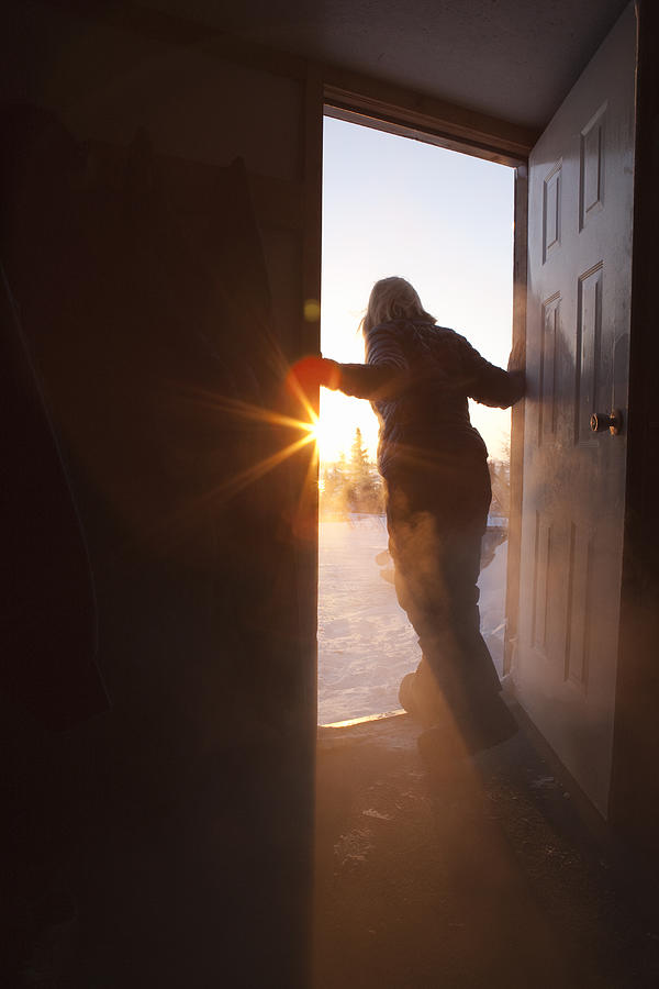 Woman in doorway looking outside Photograph by Thomas Kokta