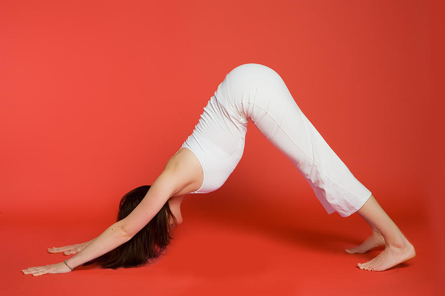 Woman in downward facing dog pose Photograph by Pkline