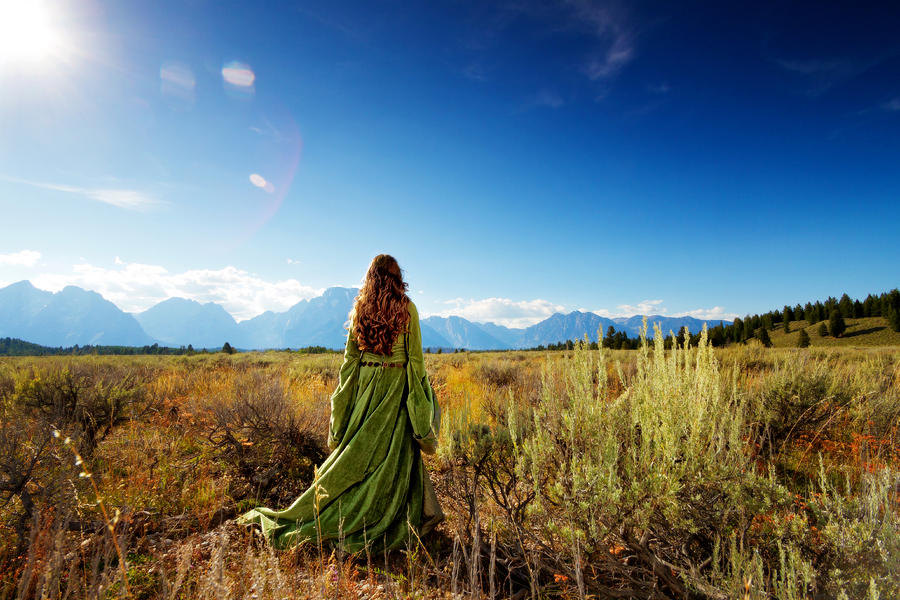 Woman in medieval gown faces mountains, rear view Photograph by Anna Gorin