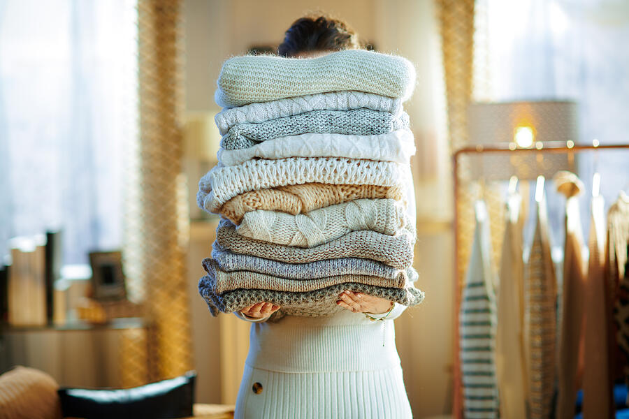 Woman In Modern House In Sunny Winter Day Holding Huge Sweaters Photograph by CentralITAlliance