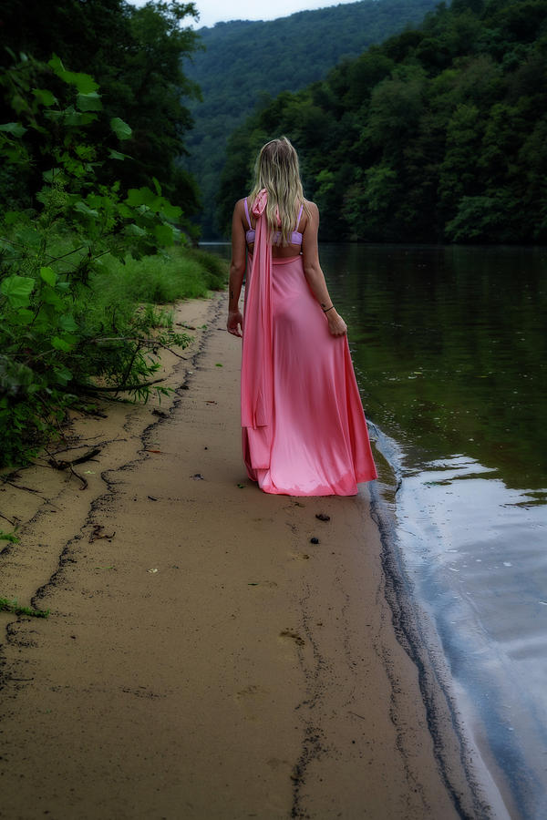 Woman in pink dress walking away on the shore Photograph by Dan Friend