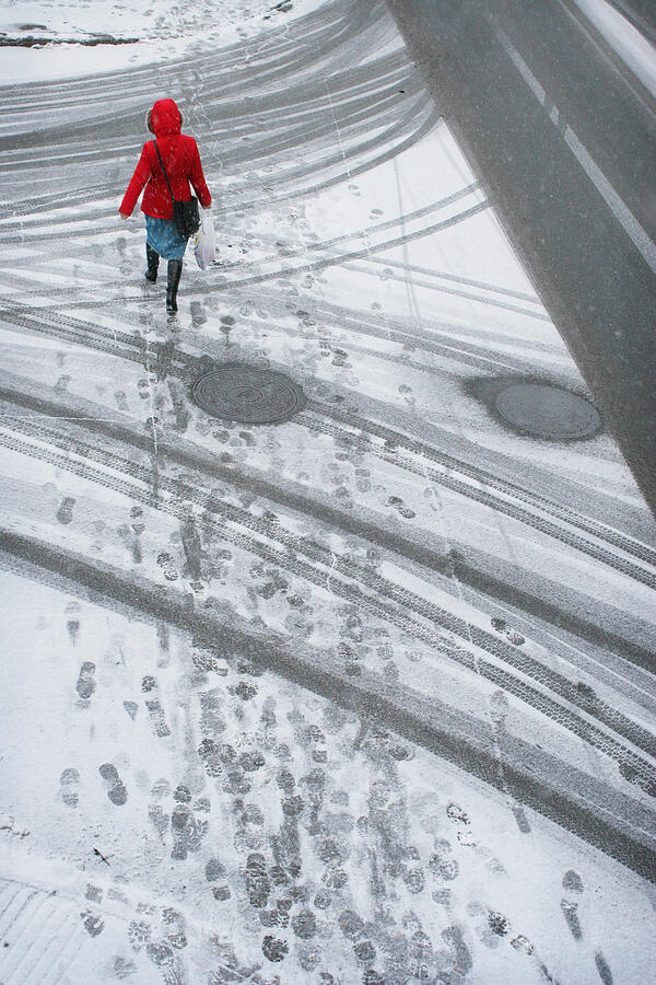 Woman in red coat walking in the snow Photograph by Jonathan Clark