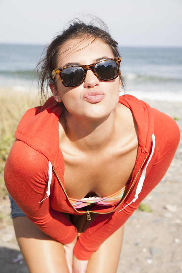 Woman in red hoodie on beach with kissing lips Photograph by Jacqueline Veissid