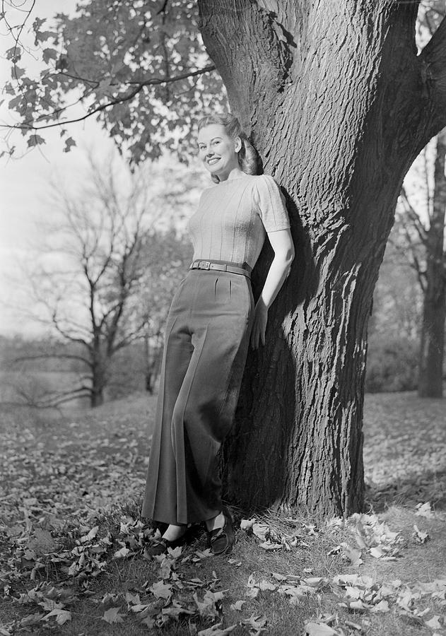 Woman leaning against tree, portrait Photograph by George Marks