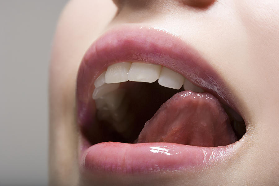 Woman licking lips Photograph by Image Source