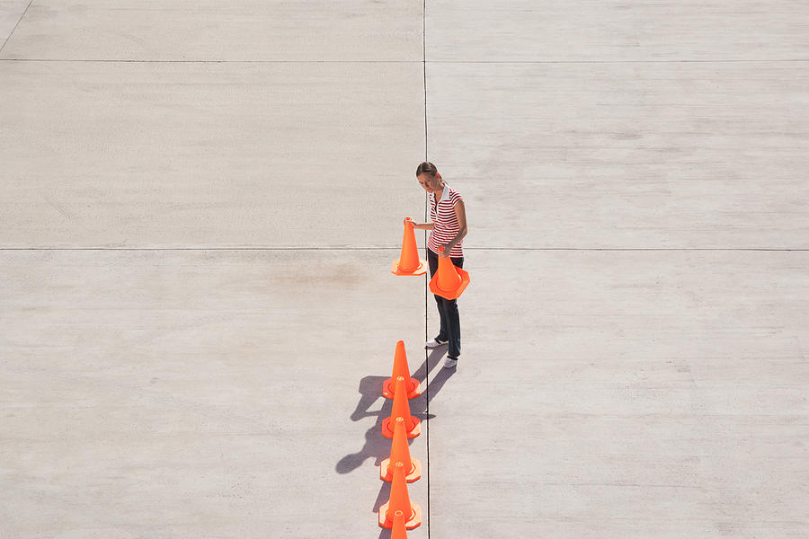 Woman lining up traffic cones Photograph by Martin Barraud