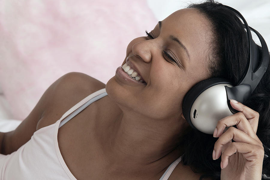 Woman listening to music with headphones Photograph by Comstock Images