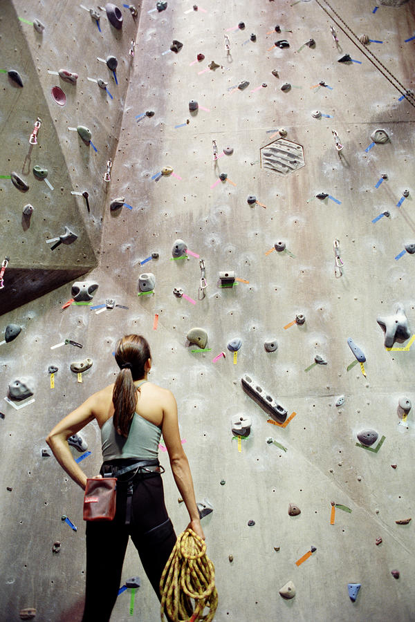 Woman looking at rock climbing wall Photograph by Jon Feingersh