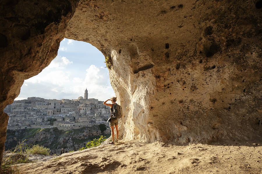 Woman looking at view from a cave of Matera, Basilicata, Italy Photograph by Deimagine
