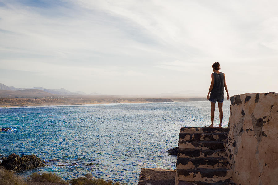 Woman looking out to sea, Corralejo, Fuerteventura, Canary Islands Photograph by Senserini Lucrezia