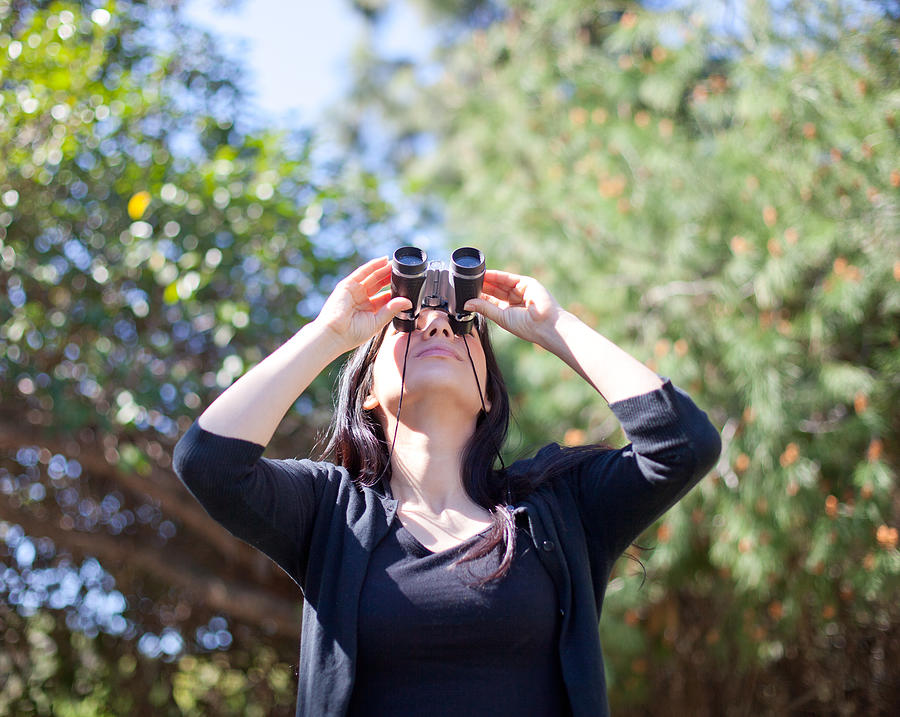 Woman looking up at sky through binoculars Photograph by Tuan Tran