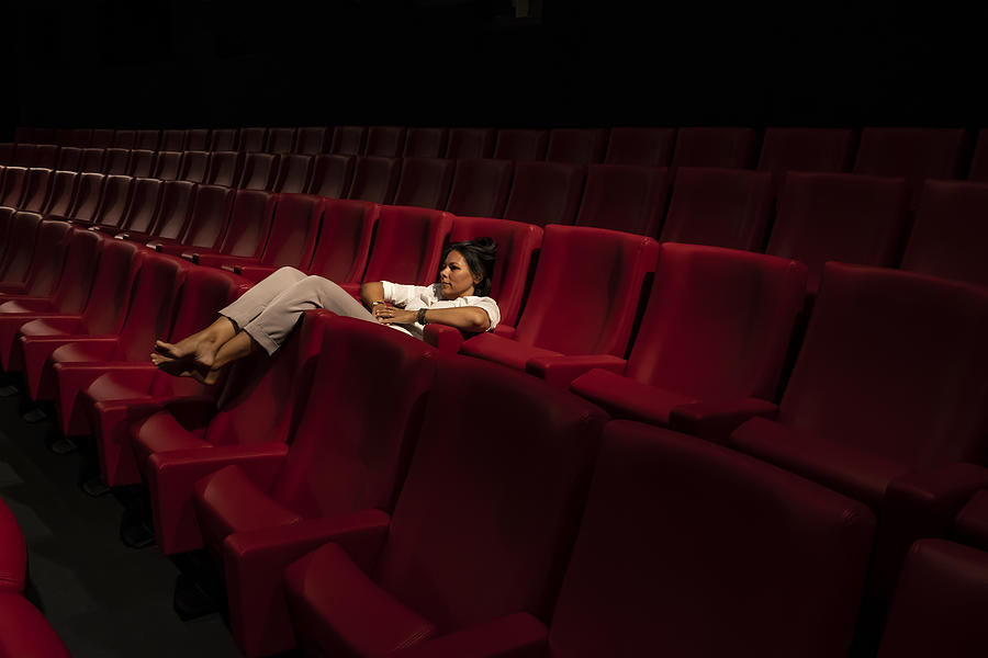Woman Lying Down Alone in a Movie Theater Photograph by Mats Silvan