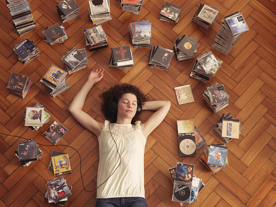 Woman lying on floor, listening to music Photograph by Jlph