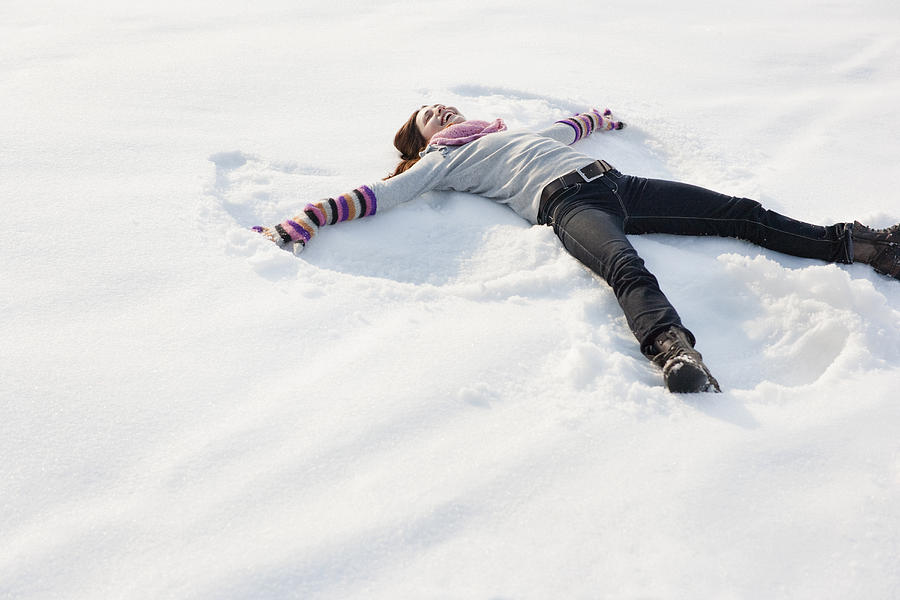 Woman making snow angel Photograph by Sam Edwards