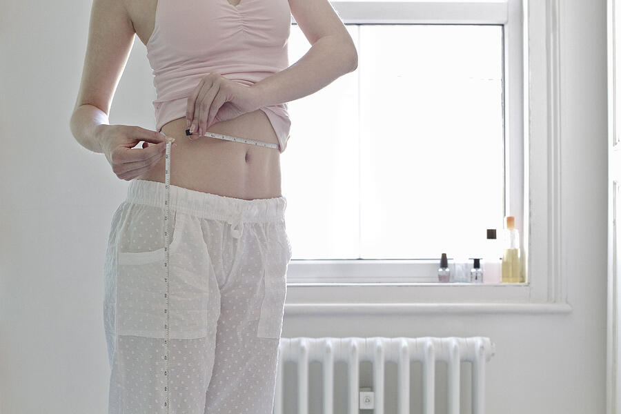 Woman measuring her waist Photograph by Flashpop