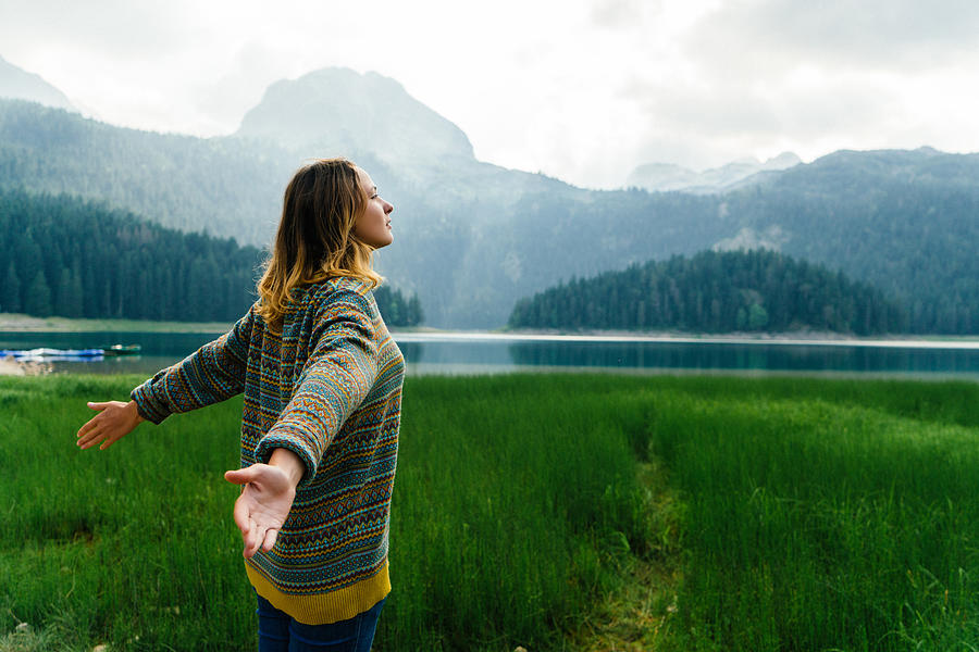 Woman near the lake in mountains Photograph by Oleh_Slobodeniuk