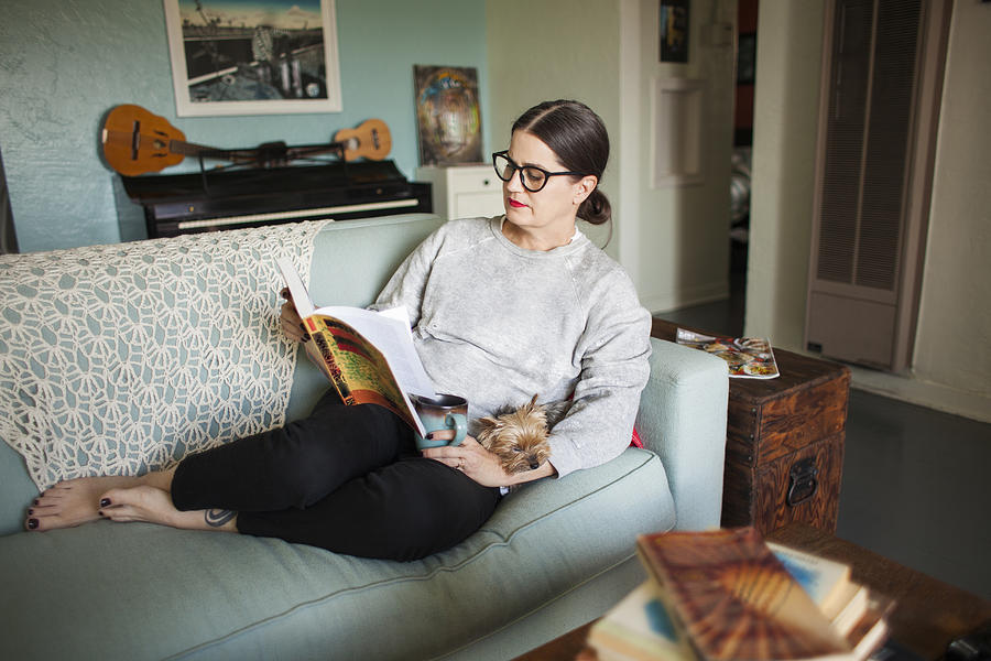 Woman on couch reading Photograph by Stephen Zeigler