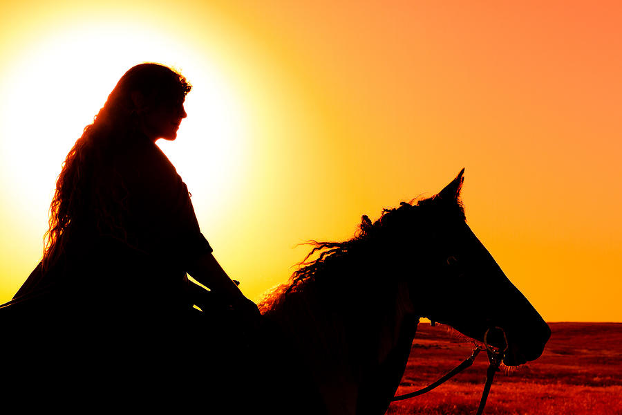 Woman on horseback silhouetted against setting sun Photograph by Anna Gorin