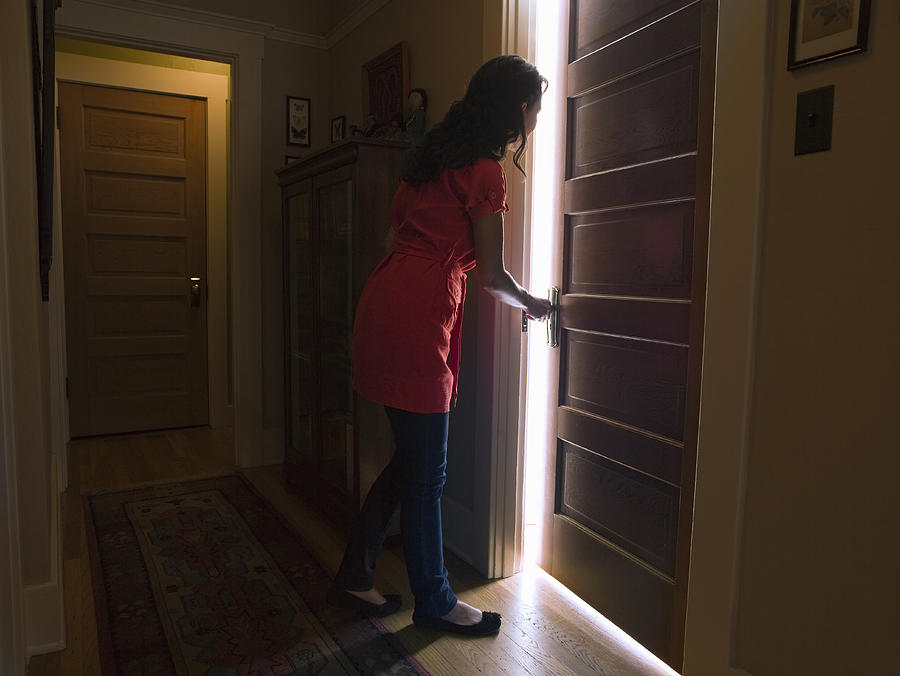 Woman opening bedroom door with light coming out Photograph by Siri Stafford