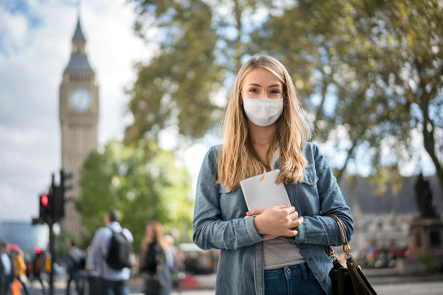Woman outdoors wearing a facemask while walking around London Photograph by Andresr
