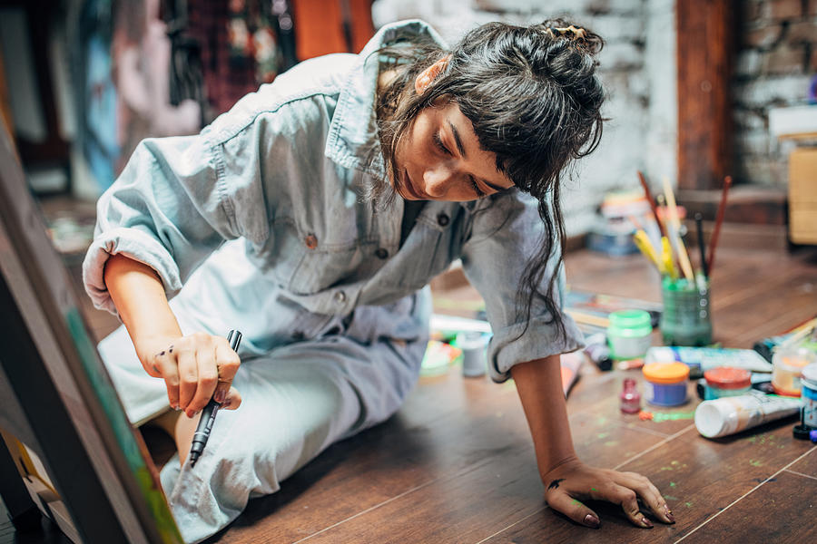 Woman painting on the floor at home Photograph by South_agency