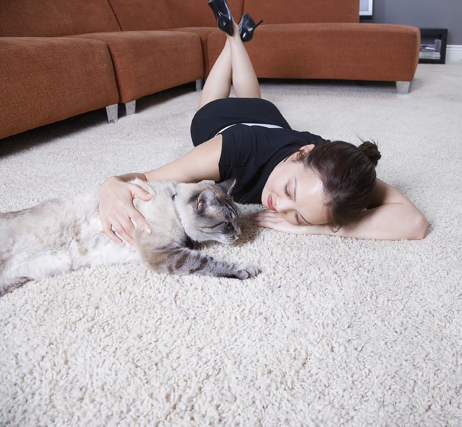 Woman petting cat on floor Photograph by Tanya Constantine