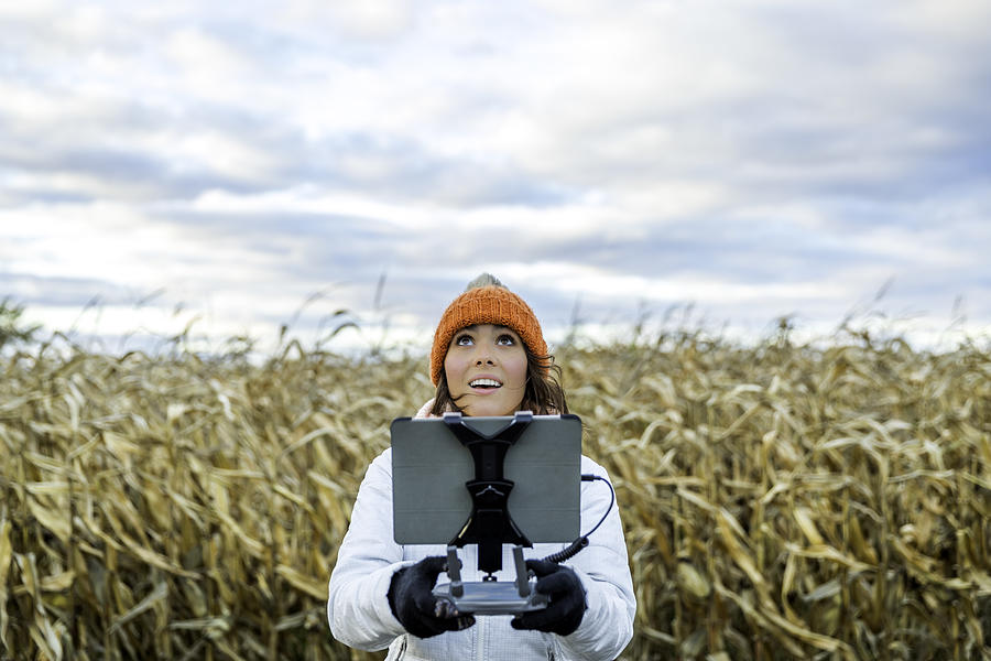 Woman Pilot Using Drone Remote Controller with a Tablet Mount Photograph by Onfokus