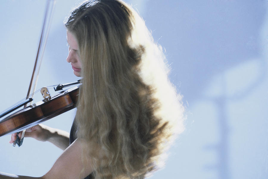 Woman playing a violin Photograph by Comstock