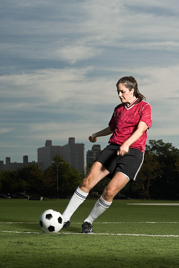 Woman playing football Photograph by Image Source