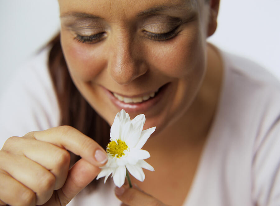 Woman plucking petals of flower Photograph by Petrol