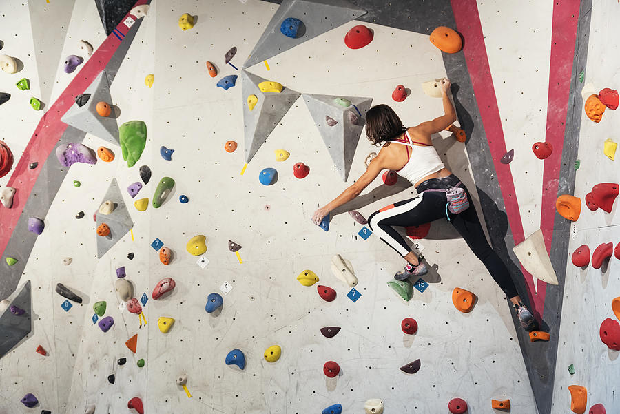 Woman practicing rock climbing on artificial wall indoors. Active lifestyle and bouldering concept. Photograph by Santypan Woman practicing rock climbing on artificial wall indoors. Active lifestyle and bouldering concept. Photograph by Santypan
