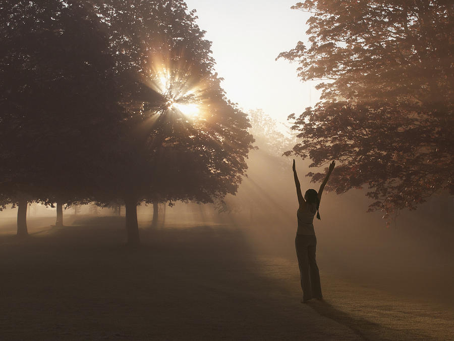 Woman practicing yoga in foggy field Photograph by Tom Merton