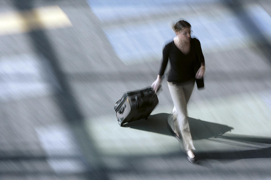 Woman pulling suitcase Photograph by Comstock Images