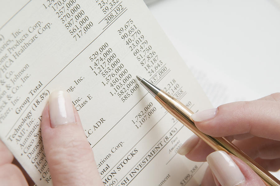 Woman reading financial planning report, close-up Photograph by Artifacts Images