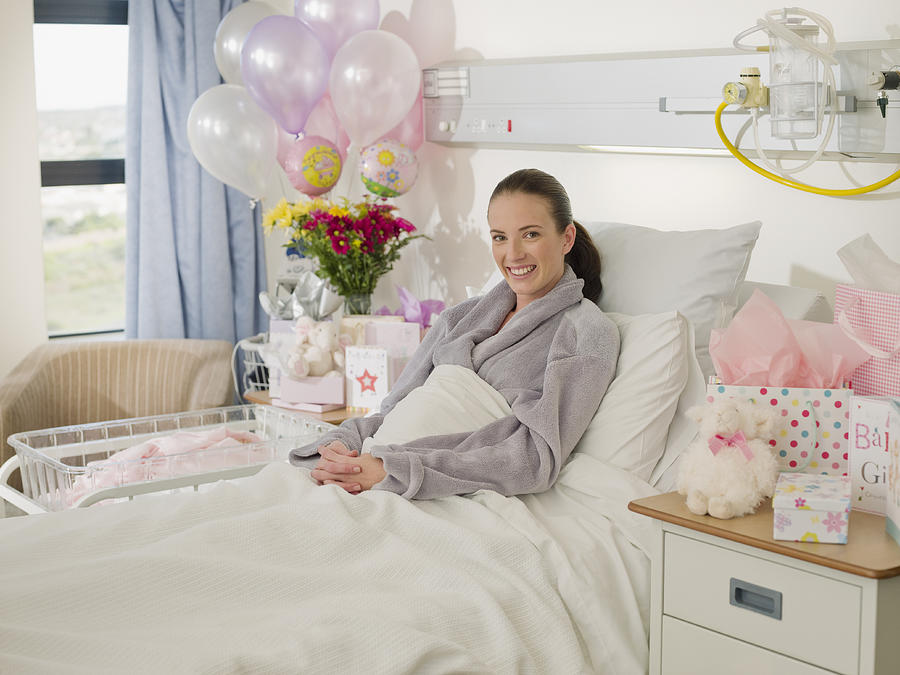 Woman recovering from birth in hospital Photograph by Chris Ryan
