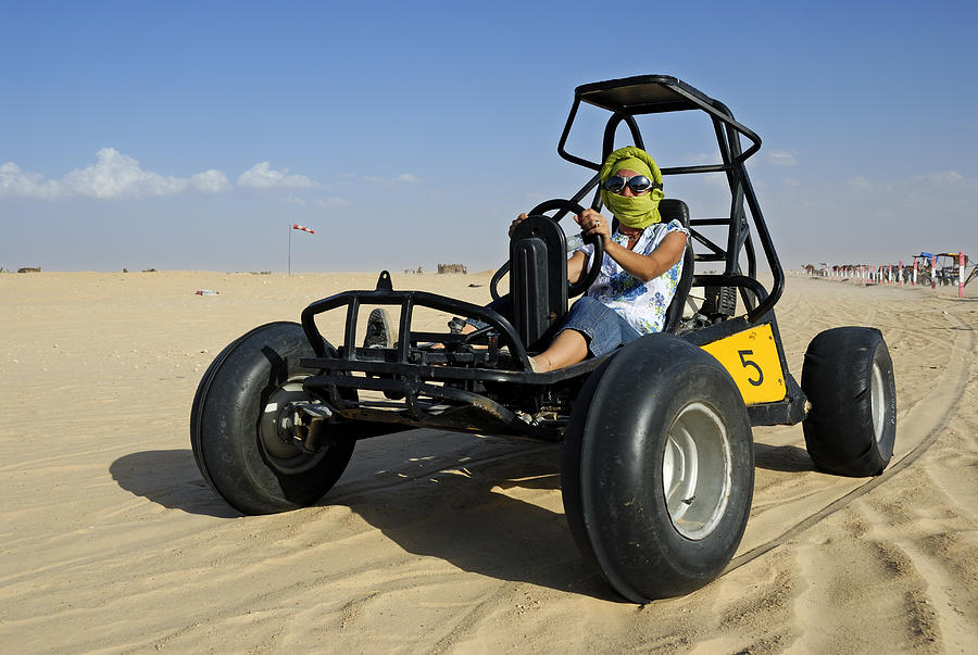 Woman riding beach buggy in desert Photograph by Sami Sarkis