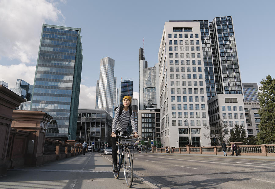 Woman riding bicycle in the city, Frankfurt, Germany Photograph by Westend61