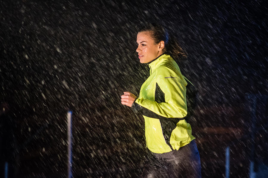 Woman running in rain Photograph by Simonkr