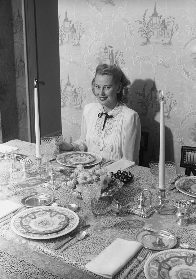 Woman sitting at dining room table, portrait Photograph by George Marks