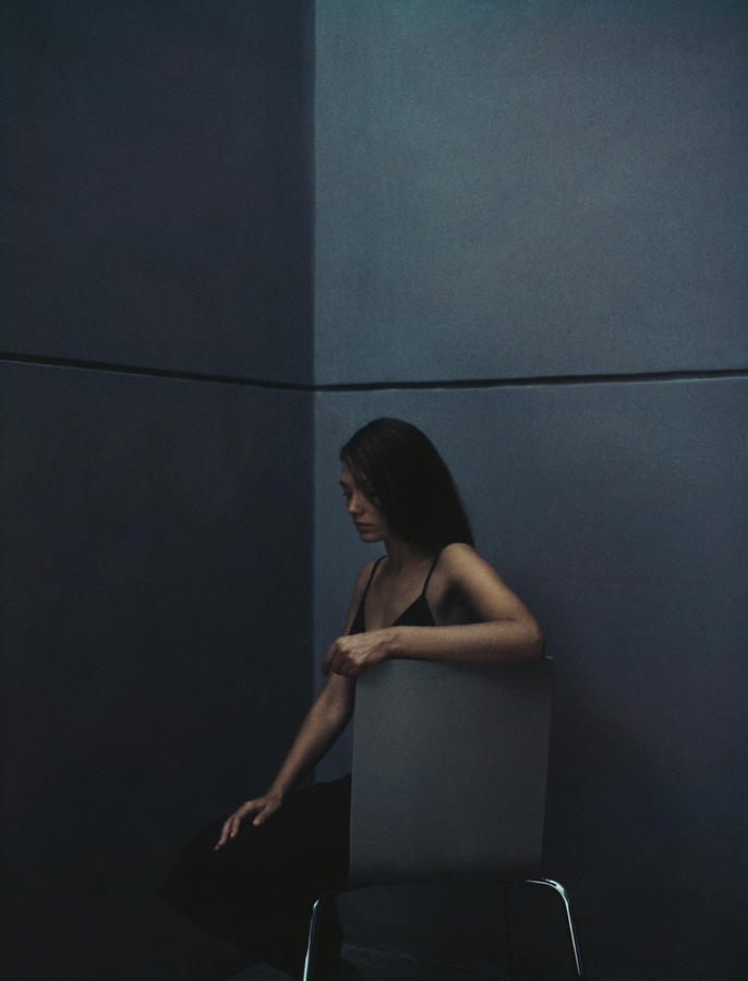 Woman sitting in a corner. Photograph by Matthieu Spohn