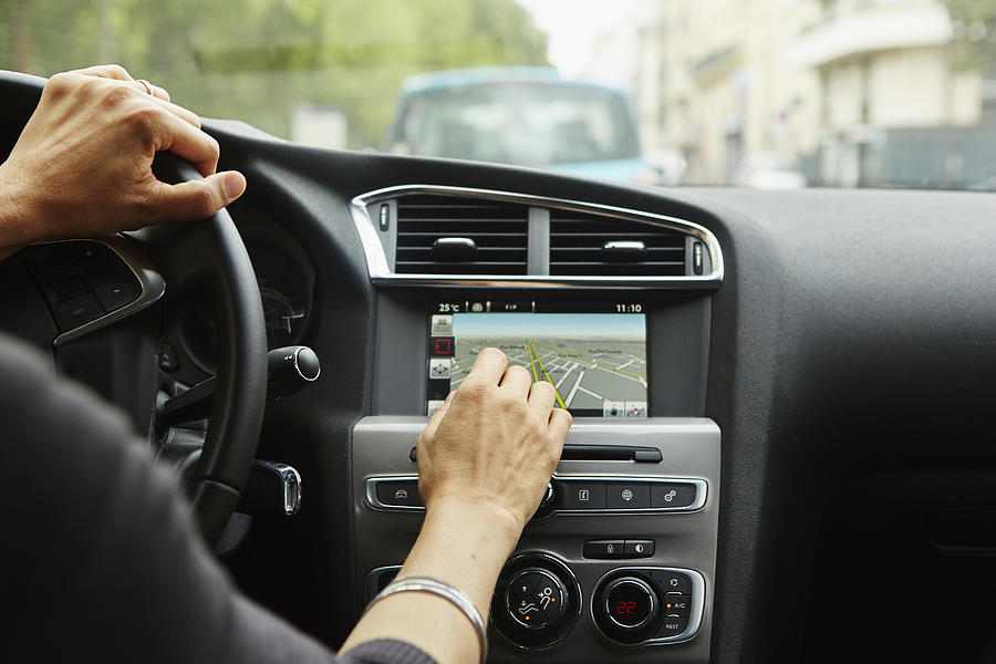 Woman sitting in car, using gps, focus on hands Photograph by Kathleen Finlay