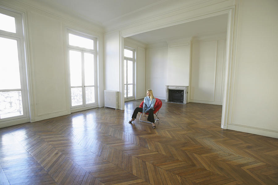 Woman Sitting on a Red Chair in a Large Empty Room Photograph by B2M Productions