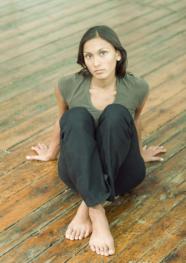 Woman sitting on floor, portrait Photograph by PhotoAlto/Axel Ley